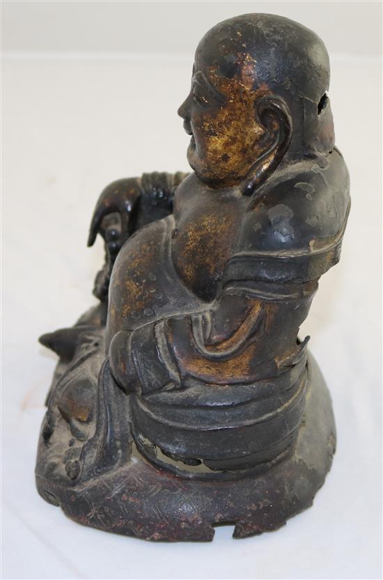 A Chinese gilt lacquered bronze seated figure of Budai, late Ming dynasty, 17cm, damage